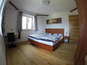Schlafzimmer mit einem Bett, einem Schreibtisch und einem Fenster in der Unterkunft Ferienwohnungen Hornmansreithof in Sankt Koloman