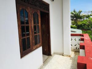 una porta per una casa con uccelli che volano all'esterno di White House a Negombo