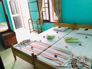 2 letti singoli in una camera con fiori di White House a Negombo