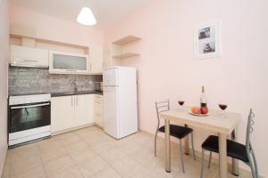 a kitchen with a table and a white refrigerator at Fotini in Agia Effimia