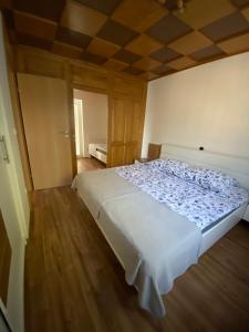 Cama blanca grande en habitación con suelo de madera en Apartma Vražič, en Bled