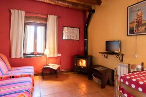 sala de estar con chimenea y TV en Casas Arana - Parque Nacional De Ordesa, en Albella