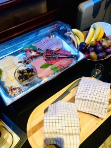 een tafel met een dienblad met eten en een dienblad met fruit bij Charming Suites Jan Zonder Vrees in Antwerpen