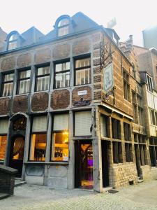 un viejo edificio de ladrillo en una calle con una tienda en Charming Suites Jan Zonder Vrees, en Amberes