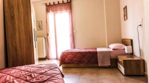 a bedroom with two beds and a window at Comfort Luxury Maisonette in Thessaloniki