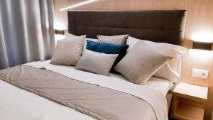 ein Bett mit einem Haufen Kissen drauf. in der Unterkunft Apartman Pod Hrebienkom - C112 in Starý Smokovec
