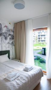 a bedroom with a bed and a large window at Rakowicka Apartments Nearto Old Town in Krakow