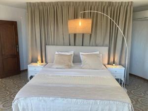 a bedroom with a large white bed with two night stands at Villa Denia Costa Blanca in Denia