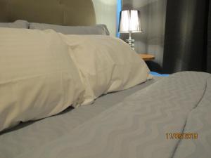 a bed with white sheets and pillows on it at E Life D Summit Residences With Wifi & Netflix in Johor Bahru