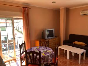 a living room with a couch and a tv and a table at Apartamento Ruidera Plaza in Ruidera