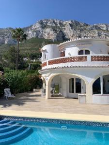 a large house with a swimming pool in front of it at Villa Denia Costa Blanca in Denia