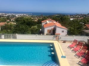 a swimming pool with chairs and a house at Villa Denia Costa Blanca in Denia