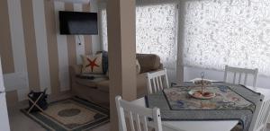 een kleine woonkamer met een tafel en een bank bij Finestra Azzurra in San Vito lo Capo