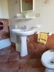 a bathroom with a white sink and a toilet at SUARA Affitti - bike in Bibbona