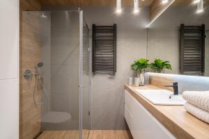 a bathroom with a glass shower and a sink at Art Apart Market Square Wrocław in Wrocław