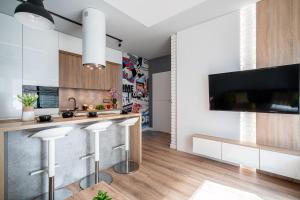 a kitchen with white cabinets and a kitchen island with stools at Art Apart Market Square Wrocław in Wrocław