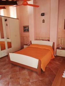 a bedroom with a large bed with an orange blanket at SUARA Affitti - bike in Bibbona