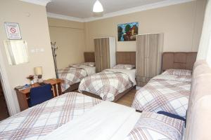 een groep van vier bedden in een kamer bij Sari Pension in Edirne