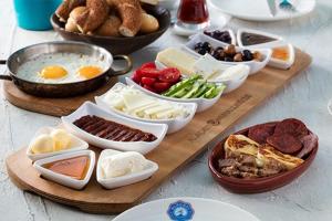 una mesa con diferentes tipos de alimentos en una mesa en Evim Zeytinlik Pension, en Gülpınar