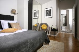 a bedroom with a bed and a chair and a mirror at Gem Apartment by Castle (Old Town Krakow) in Krakow