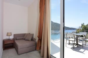 a living room with a couch and a balcony at Hotel Aktaion in Tolo