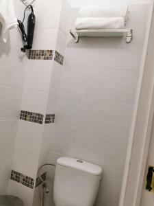 Baño blanco con aseo y toalla en Cosy Europarlament apartment, en Bruselas 5 fotos más