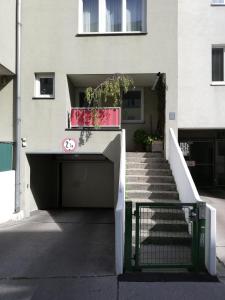 ein Gebäude mit einem Tor und einer Treppe davor in der Unterkunft Room in maisonette with garden, parking place in Wien