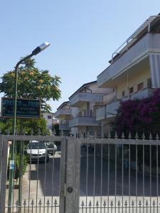una valla frente a un edificio con aparcamiento en Camere da Franco, en Santa Maria del Cedro