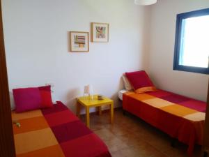 Zimmer mit 2 Betten, einem Tisch und einem Fenster in der Unterkunft Villa la 29 in Playa Blanca