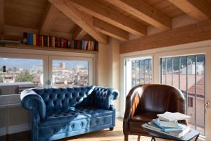 a blue couch and a chair in a room with windows at Locanda delle Mercanzie in Brescia +53 photos