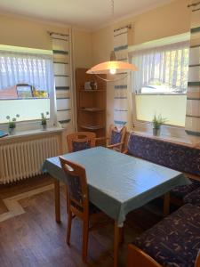 a dining room with a table and chairs and windows at Haus Gorch Fock in Neuharlingersiel