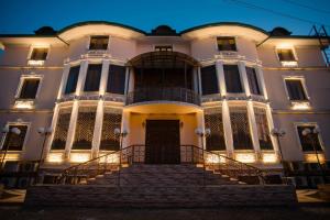 a large white building with stairs in front of it at Caravan Castle Boutique Hotel in Bukhara