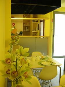 uma sala de jantar com paredes amarelas e uma mesa e cadeiras em Albergo Verdi em Pádua