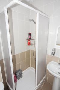 a shower stall in a bathroom with a sink at Sari Pension in Edirne