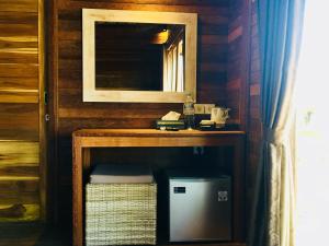 a bathroom with a mirror and a small refrigerator at Gedong Nusa Huts in Nusa Lembongan