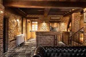 a living room with a leather couch in a brick wall at Appart-Hotel Léopold Liège Centre in Liège