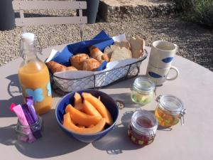 einen Tisch mit einem Korb Brot und einer Schale Karotten in der Unterkunft Le Pod de L'Adret in Rians