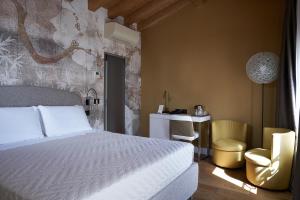 a bedroom with a bed and a desk and a chair at Locanda delle Mercanzie in Brescia
