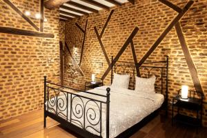 - une chambre avec un lit noir dans un mur de briques dans l'établissement Appart-Hotel Léopold Liège Centre, à Liège
