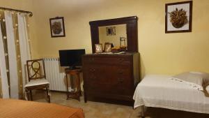ピアンカスタニャーイオにあるAgriturismo Podere dei Ventiのベッドルーム(ドレッサー、鏡、ベッド付)
