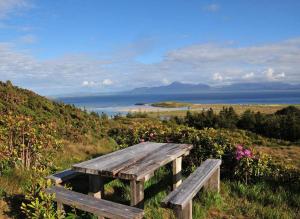 een houten bank op een heuvel met uitzicht op de oceaan bij Mulranny House in Mulranny