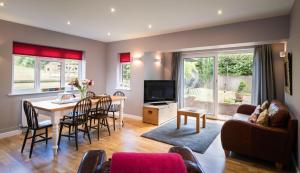 a living room with a table and a dining room at Hunters Lodge Exeter in Poltimore