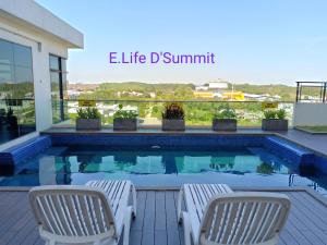 a swimming pool with two chairs next to a building at E Life D Summit Residences With Wifi & Netflix in Johor Bahru +14 photos