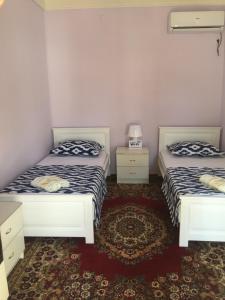 a room with two beds and a carpet at Munis in Samarkand