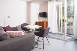 a living room with a couch and a table with chairs at NordseeHeide-Lodges Cuxhaven in Cuxhaven