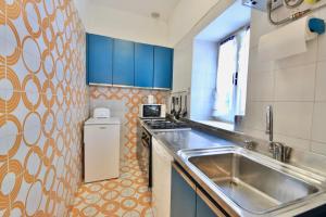 a kitchen with a stainless steel sink and blue cabinets at Vela Portofino by KlabHouse in Portofino