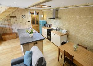 Luxury Barn House - Central Oxford/Cotswolds في Cassington: مطبخ وغرفة معيشة مع طاولة ومكتب
