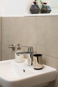 un lavabo con un grifo cromado. en BENSIMON apartments Charlottenburg, en Berlín 26 fotos más