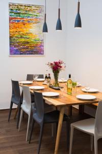 a dining room table with chairs and a painting on the wall at BENSIMON apartments Charlottenburg in Berlin