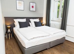 Un dormitorio con una cama grande con sábanas blancas. en BENSIMON apartments Charlottenburg, en Berlín